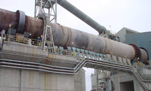 Hot end of medium sized modern cement kiln, showing tyres, rollers and drive gear